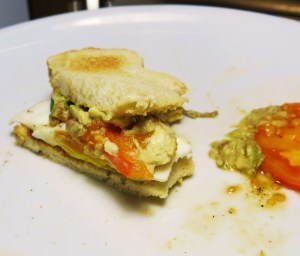 The Last Bites of an Avocado, Fried Egg and Tomato Sandwich