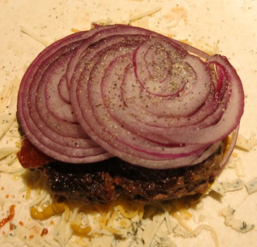 Thinly Sliced Raw Red Onion on a Burger