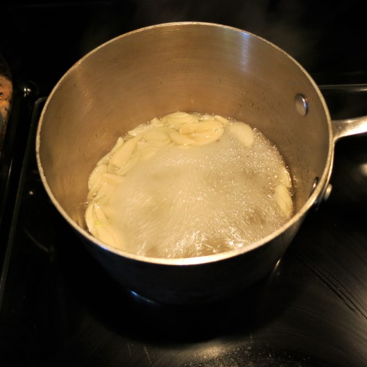 Adding the Sliced Garlic to the Syrup for Candied Jalapeño Peppers