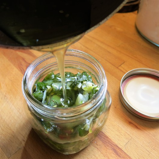 Pouring the Reduced Syrup over the Candied Jalapeño Peppers